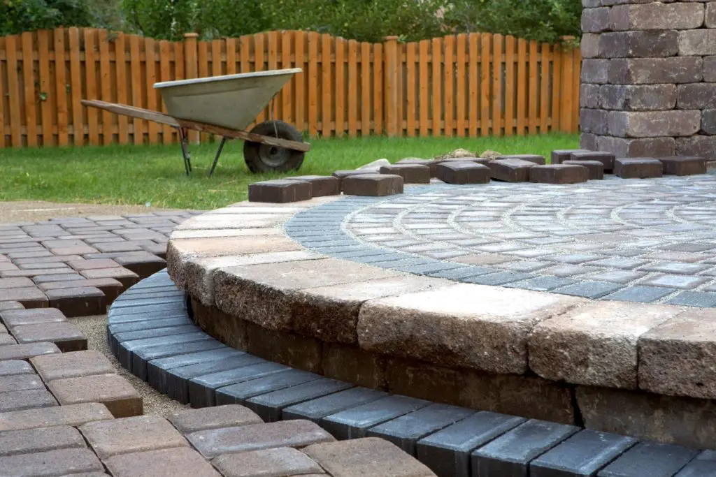 A brick patio with a circular design in the middle.