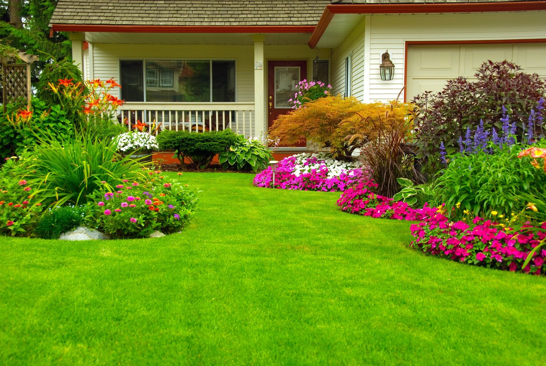 A house with a lawn and flowers in the yard.