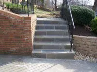 A cement staircase with steps leading to the top of it.