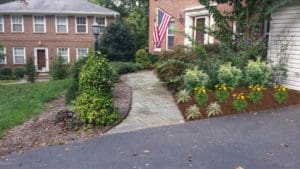 A garden with a flag and bushes in the background.